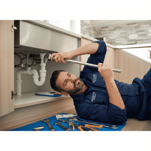 A professional working on a kitchen sink, representing residential plumbers Johannesburg homeowners trust.