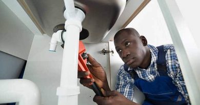 Young African Handyman Repairing Sink Pipe With Worktool Young African Handyman Repairing Sink Pipe With Worktool